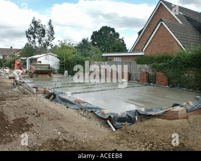 Arbeiter arbeiten auf nassen lieferte vor kurzem fertig gemischte Beton Bodenplatte gießen in Plastikplanen feuchten nachweis membran erwartet Randbeschnitt UK Stockfoto