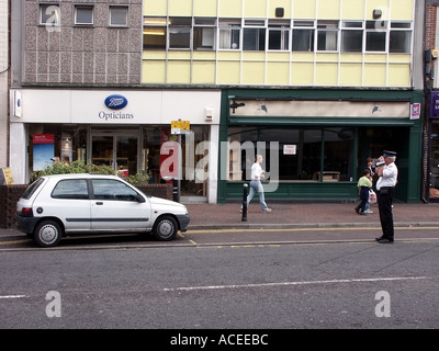 Sequenz von 3 Bildern Verkehrsaufseher bei der Arbeit, der Parkschein an illegal geparkte Autos ausstellt, fotografiert Beweise in Brentwood Essex England Großbritannien Stockfoto