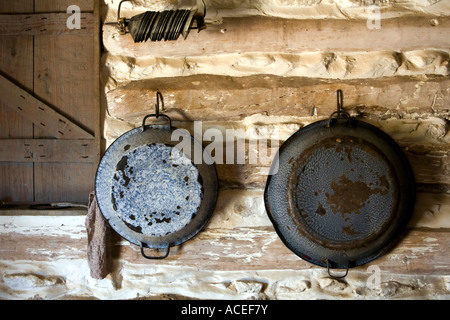 Pioneer Cabin Gericht Pfannen auf Blockwand Stockfoto