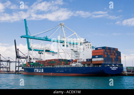 Containerschiff mit Fracht beladen angedockt an Port of Miami neben riesigen Kräne an der Biscayne Bay in Miami, Florida Stockfoto