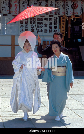 Frau, die einen traditionellen weißen Kimono mit Kapuze trägt, während der Hochzeitszeremonie mit ihrer Mutter am Meiji Jingu-Schrein in Tokio, Japan. Stockfoto
