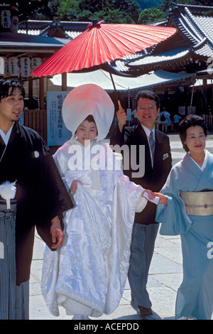 Braut und Bräutigam im traditionellen Kimono gehen bei einer Trauungszeremonie am Meiji Jingu-Schrein in Tokio, Japan. Stockfoto