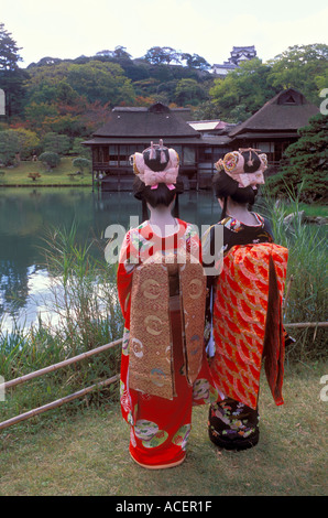 Zwei Frauen, gekleidet in historischen Kostümen des Adels genießen Sie Blick auf das Schloss im Genkyuen Garden in Hikone Japan Stockfoto