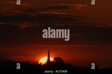 Die untergehende Sonne hinter eine Silhouette Kirchturm In Staffordshire England. Stockfoto