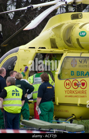 Flugrettung Motocross Veranstaltung Gruppe von Medizinern laden verletzte Patienten in Hubschrauber Stockfoto