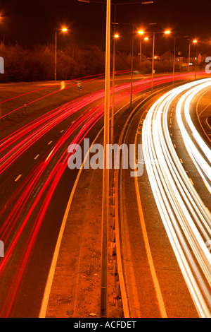 Beschleunigung Lichtspuren von Verkehr auf einer belebten Straße in der Nacht, allgemeine Straßen, Autobahn Stockfoto