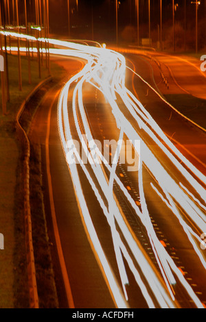 Beschleunigung Lichtspuren von Verkehr auf einer belebten Straße in der Nacht, allgemeine Straßen, Autobahn Stockfoto