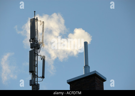 Antenne für Mobilfunk-Übertragung und Rauchen Schornstein auf einem Hausdach in Zürich, Schweiz. Stockfoto