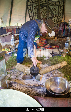 "Medizin-Brother" Phil neigt dazu, das Feuer im Inneren einer Familiengröße Tipi. Glastonbury Festival 2007, Somerset, England Stockfoto