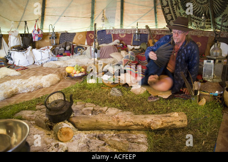 "Medizin-Brother" Phil neigt dazu, das Feuer im Inneren einer Familiengröße Tipi. Glastonbury Festival 2007, Somerset, England Stockfoto