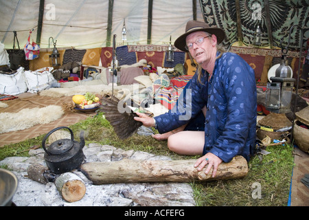 "Medizin-Brother" Phil neigt dazu, das Feuer im Inneren einer Familiengröße Tipi. Glastonbury Festival 2007, Somerset, England Stockfoto