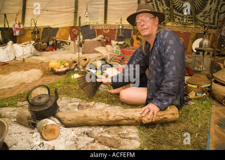 "Medizin-Brother" Phil neigt dazu, das Feuer im Inneren einer Familiengröße Tipi. Glastonbury Festival 2007, Somerset, England Stockfoto