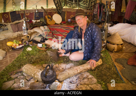 "Medizin-Brother" Phil neigt dazu, das Feuer im Inneren einer Familiengröße Tipi. Glastonbury Festival 2007, Somerset, England Stockfoto