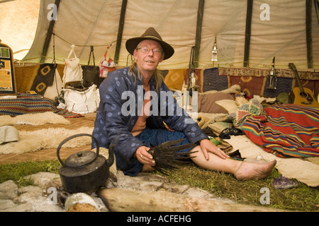 "Medizin-Brother" Phil neigt dazu, das Feuer im Inneren einer Familiengröße Tipi. Glastonbury Festival 2007, Somerset, England Stockfoto