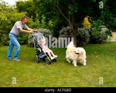 Grossvater Enkelin Hund Spaß im Garten in Surrey England Stockfoto
