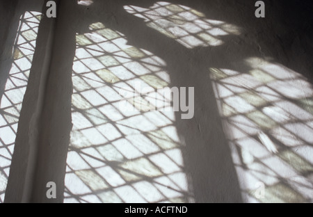 Die Projektion senkrecht Diamanten Bleiglasfenster mit unebenen handgemachte Glas auf einer weiß gestrichenen Wand Stockfoto