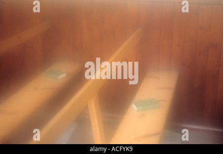 Atmosphärische Rohöl einfache Holzbank Sitze mit grünen Bücher verstreut und mit Beplankung bekleideten Wände Stockfoto