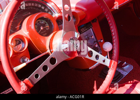 Armaturenbrett-Lenkrad und Schalthebel eines roten 1962 Chevrolet Corvette Oldtimers auf einer Automesse Stockfoto