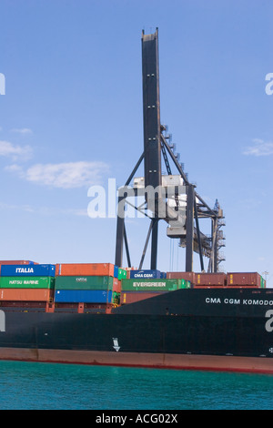 Riesigen Kran neben Containerschiff mit Fracht beladen angedockt am Hafen von Miami in Florida Stockfoto