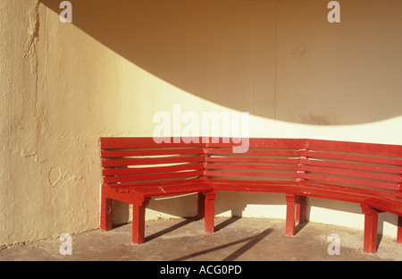 Eine rote Sitzbank in einem modernistischen Rundschreiben Creme Tierheim gießen ein interessantes Detail gebogen Schatten Stockfoto