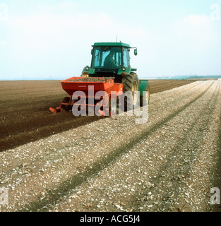 John Deere Traktor mit 2-reihigen Kartoffel Pflanzmaschine arbeiten auf einem steinigen Kalksteingebieten Boden Stockfoto