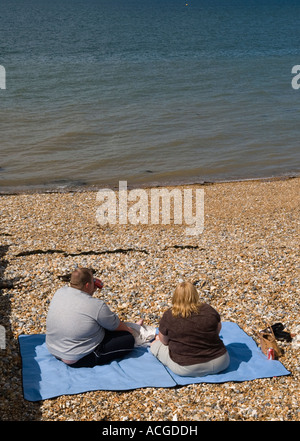 Fett paar allein am Strand mit Blick auf das Meer. Tankerton in der Nähe von Whitstable Kent England HOMER SYKES Stockfoto