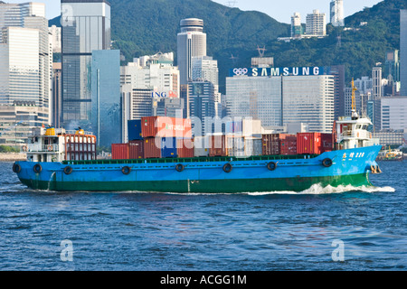 Schiff, beladen mit Containern im Victoria Harbour mit Skyline Hong Kong SAR Stockfoto