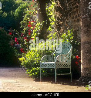 Gartensitz Vintage antiken Metall verzierten Gitterstuhl, in sonnigem englischem Zuhause formeller Landgarten, unter schattiger Laubenpergola, in der Sommersonne Stockfoto