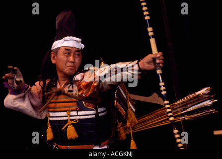 Ein japanischer Krieger Schauspieler schießen Pfeil und Bogen im Bogenschießen-Ritual-Bühnen-Performance und tragen Tracht aus Japan Stockfoto