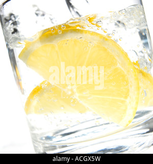 Ein Glas Gin und Tonic mit pikanter Zitronenscheibe erschossen auf einem weißen Hintergrund Stockfoto