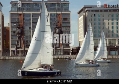 Segelboote, vorbei an Hotels und Ferienwohnungen in der Nähe von Excel Exhibition Centre am Royal Victoria Dock London UK Stockfoto