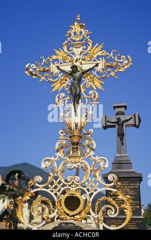 Sehr dekoriert im Barockstil vorgenommenen christliches Kreuz golden Schmiedeeisen in einer bayerischen Kirchhof, Deutschland. Stockfoto