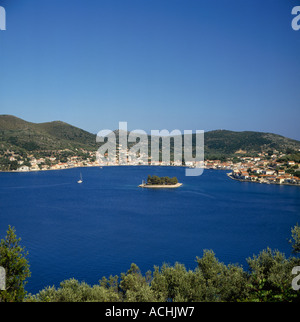 Blick über Sträucher über Bucht mit Yacht Segeln und Lazareto Islet Vathi Stadt Ithaki Insel der griechischen Inseln Griechenland Stockfoto