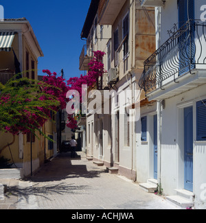 Seitenstraße der traditionellen Gebäude in Lefkada mit eisernen Balkonen Bougainvillea Junggeselle & Auto auf Lefkas Insel der griechischen ist Stockfoto