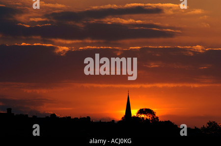 Die untergehende Sonne hinter eine Silhouette Kirchturm In Staffordshire England. Stockfoto