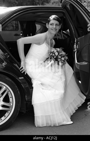 Braut an ihrem Hochzeitstag Hochzeit Auto Limousine Ausstieg Stockfoto