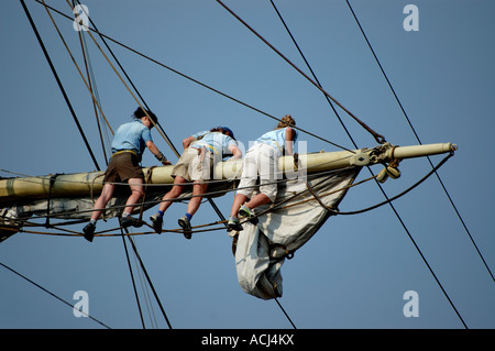 Stehend auf der Footropes, die Segel auf einem Platz zu verstauen manipuliert Schiff bei Mystic Seaport in Connecticut Stockfoto