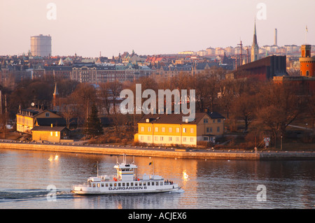 Ein Abend-Blick über Stockholm Strom Strommen mit einem alten Stil Passagier Fähre Boot Djurgarden auf dem Wasser vor Kastellholmen und Östermalm im Hintergrund Sonne Spiegelungen im Wasser Stockholm, Schweden, Sverige, Europa Stockfoto