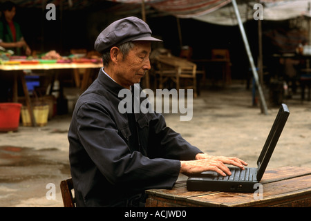 Alte chinesische Mann auf Laptop-Computer in Shanghai China Stockfoto