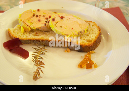 Zwei große Scheiben Gänseleber, Entenleber mit einigen rose rote Paprika auf auf eine Scheibe Brot mit etwas Wein Gelee mit süßen weißen Wein Monbazillac Ferme de Biorne Ente und Geflügel serviert, Bauernhof Dordogne Frankreich Workshop zu Gänseleber Entenleber Pastete und andere Konserven Stockfoto