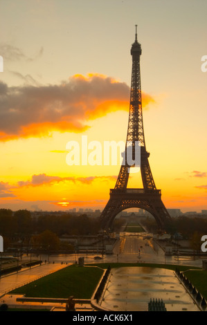 Der Eiffelturm in Paris im frühen Morgengrauen mit der aufgehenden Sonne am Horizont, hellblau sky, einige weiße Wolken und die Sonne golden gelb gesehen vom Place Trocadero Square Paris Frankreich Stockfoto