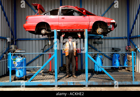 Entfernen von Flüssigkeiten aus einem Auto vor dem recycling bei einer autorisierten Verwertungsanlage in Newport South Wales UK Stockfoto