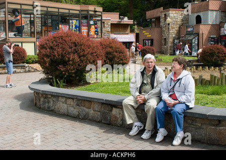 Älteres paar ruht auf Steinbank in der Innenstadt von shopping-district in Gatlinburg, Tennessee Stockfoto