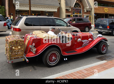 Mann zeigt leuchtend roten Jaguar Installationssatzauto auf Straßen von Gatlinburg, Tennessee, USA Stockfoto