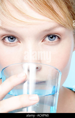 Junge Frau trinkt ein Glas Wasser Stockfoto