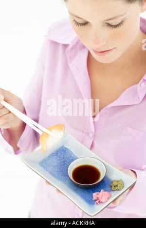 Junge Frau Sushi-Essen Stockfoto