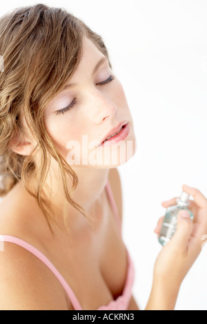 Eine junge Frau sprühen Parfüm Stockfoto