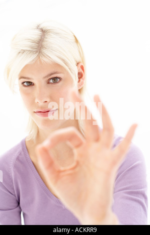 Eine junge Frau macht ein Handzeichen Stockfoto