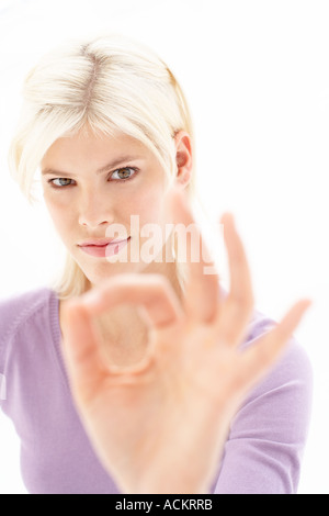 Eine junge Frau macht ein Handzeichen Stockfoto