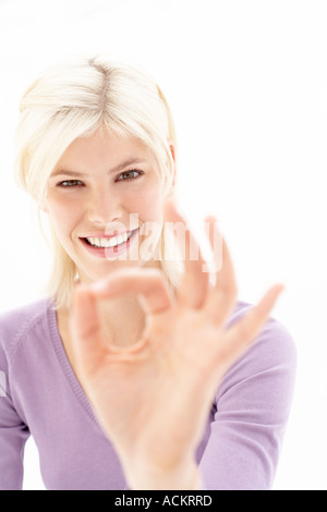 Eine junge Frau macht ein Handzeichen Stockfoto